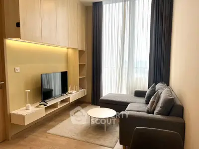Modern living room with sleek furniture and large window, offering a cozy and inviting atmosphere.