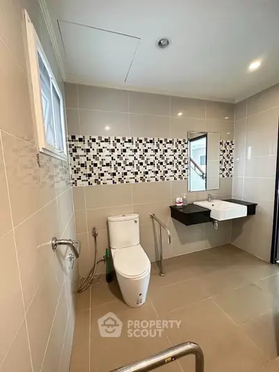 Modern bathroom with accessible features and stylish tile design.