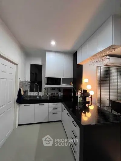 Modern kitchen with sleek black and white cabinetry and stylish lighting