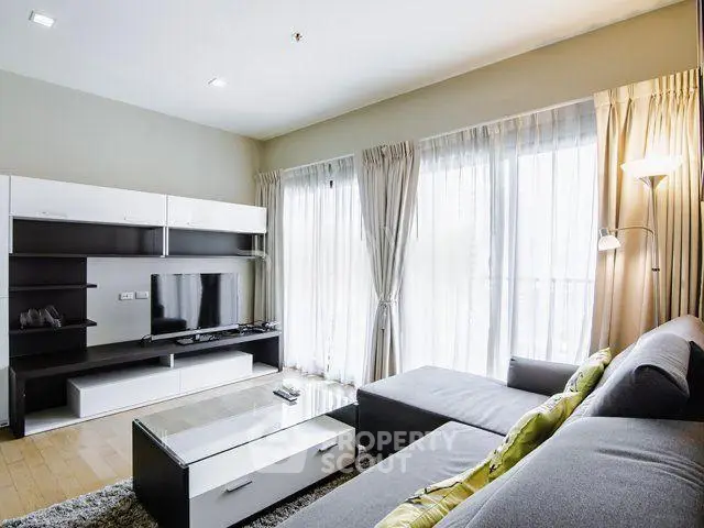 Modern living room with sleek furniture and large windows for natural light.