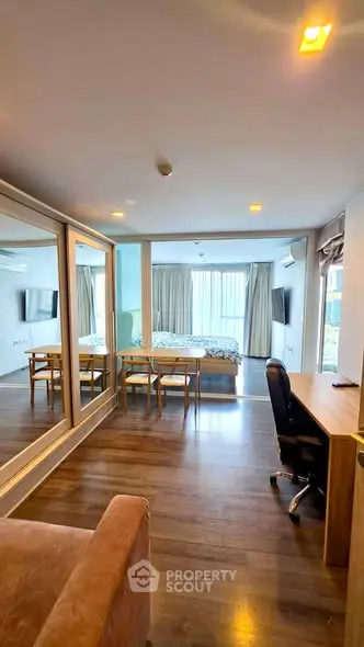 Spacious studio apartment with modern furnishings and large windows offering ample natural light.