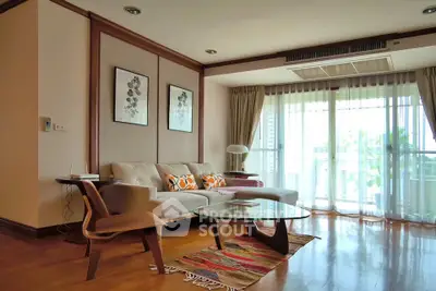 Spacious living room with modern decor and large windows offering natural light.