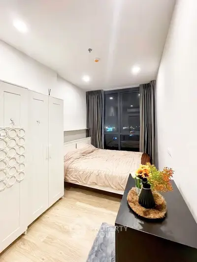 Cozy bedroom with modern decor and large window offering city view