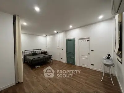 Spacious modern bedroom with minimalist decor and wooden flooring