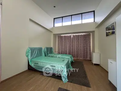 Spacious bedroom with twin beds and large windows for natural light.
