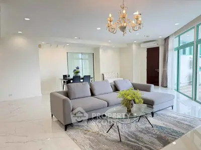 Luxurious living room with elegant chandelier and modern furniture in a spacious open layout.