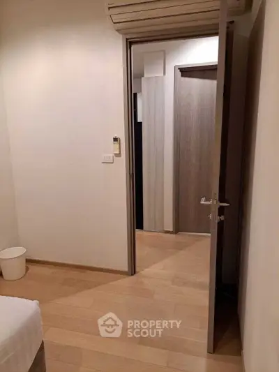 Cozy bedroom with wooden flooring and modern air conditioning unit.