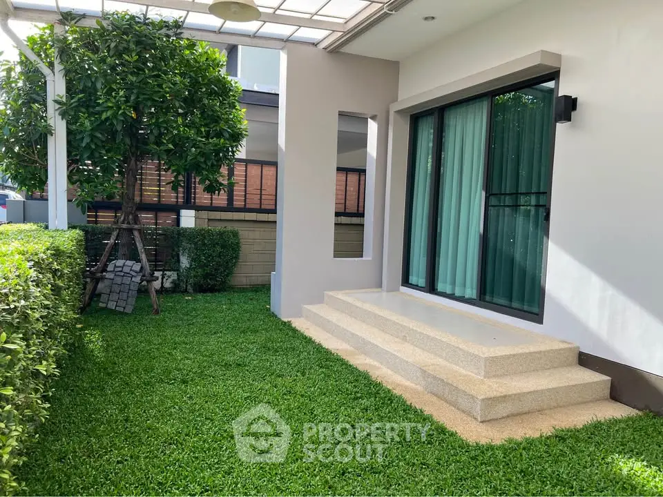 Charming garden view with lush greenery and modern patio steps in a serene residential setting.