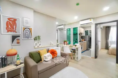 Modern open-plan living room with stylish decor and compact kitchen in a cozy apartment.