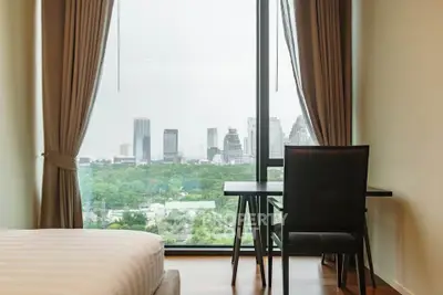Modern bedroom with city view and workspace, featuring large window and elegant curtains.