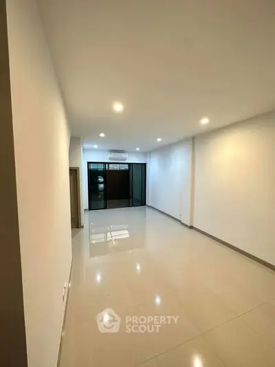 Spacious unfurnished living room with bright lighting and large windows.