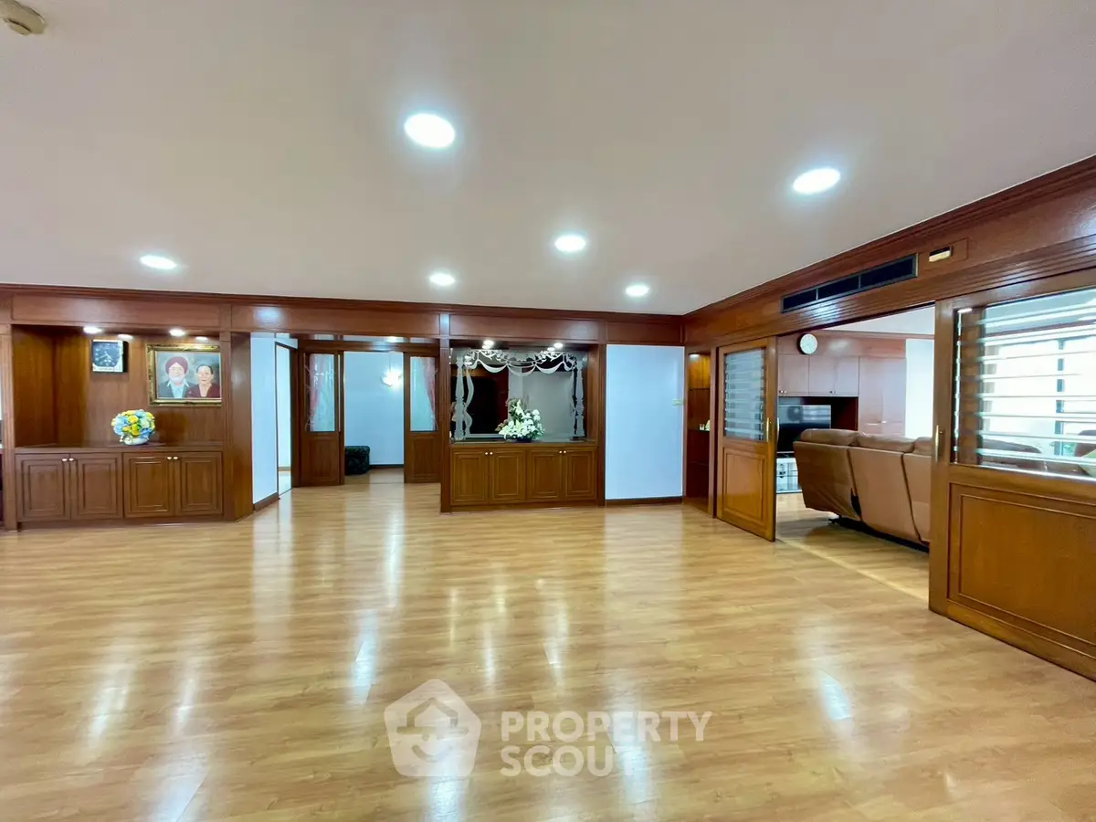 Spacious living room with wooden flooring and elegant decor in a luxurious home.
