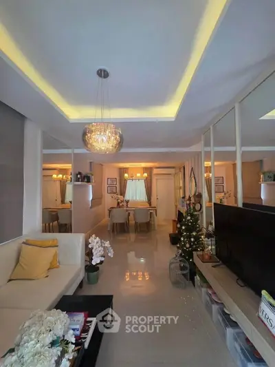 Elegant living room with modern lighting and cozy dining area, perfect for stylish urban living.