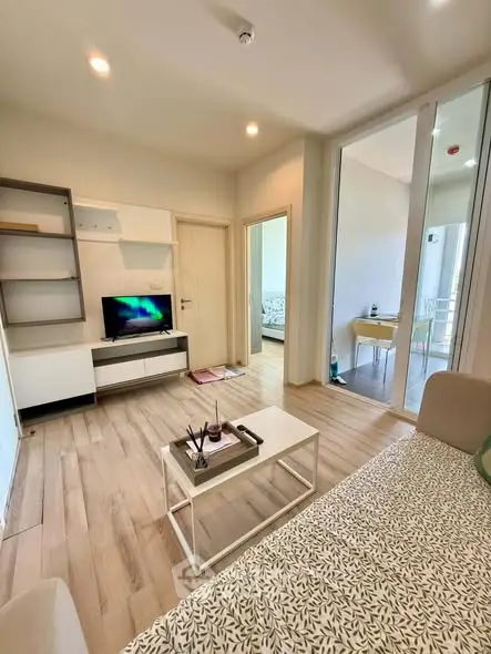 Modern living room with sleek design and natural light, featuring a cozy seating area and stylish decor.