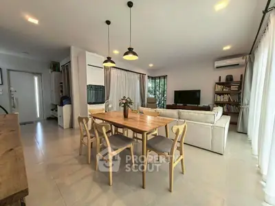Spacious modern living room with dining area, natural light, and stylish decor.