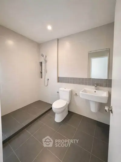 Modern bathroom with sleek design, featuring a walk-in shower and contemporary fixtures.