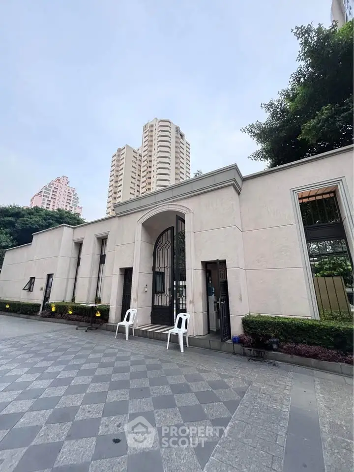 Elegant building entrance with modern design and high-rise backdrop