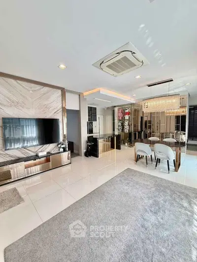 Luxurious open-plan living room with modern decor and elegant dining area, featuring sleek furniture and ambient lighting.