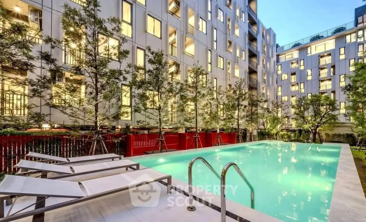 Luxurious apartment complex with illuminated pool and modern architecture