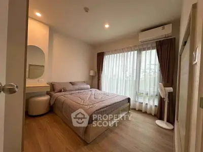 Cozy bedroom with modern decor and large window offering natural light