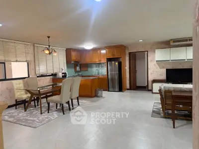 Spacious open-plan living and dining area with modern kitchen and elegant decor.