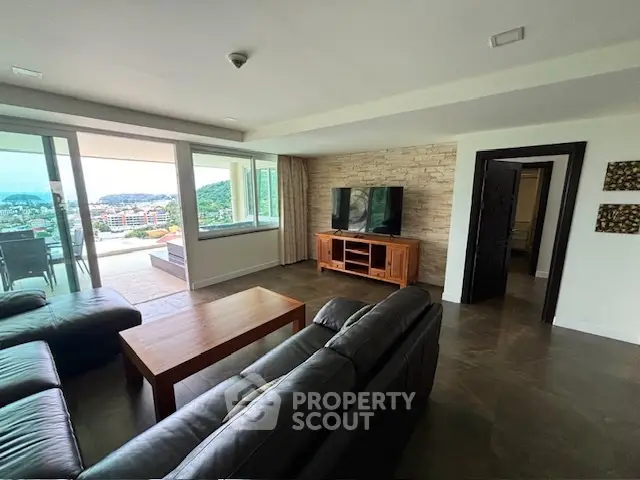 Spacious living room with modern furniture and stunning city view from large windows.
