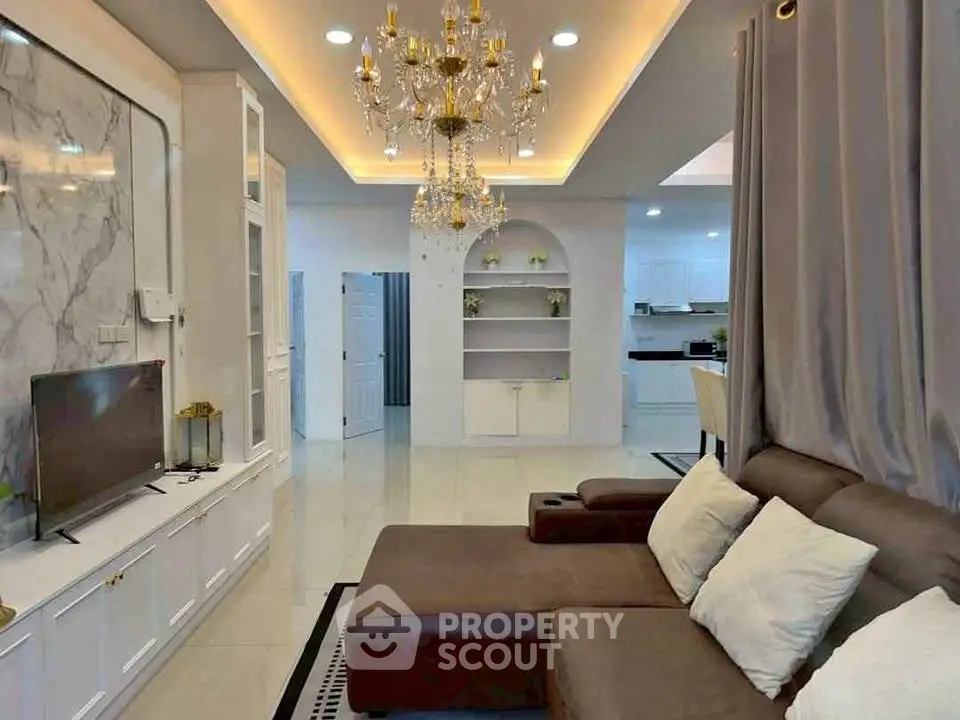 Luxurious living room with elegant chandelier and modern open kitchen layout