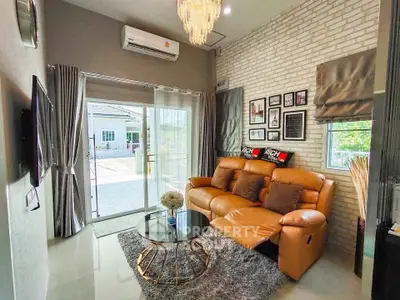 Stylish living room with leather sofa, chic decor, and natural light from large sliding doors.