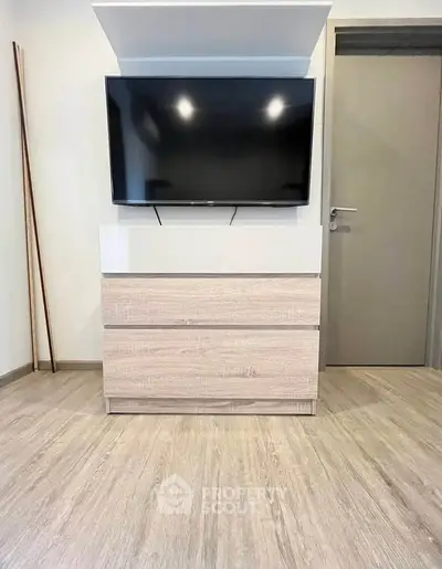 Modern living room with sleek TV setup and stylish wooden flooring