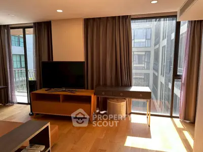 Modern living room with large windows and stylish furniture in a high-rise apartment.