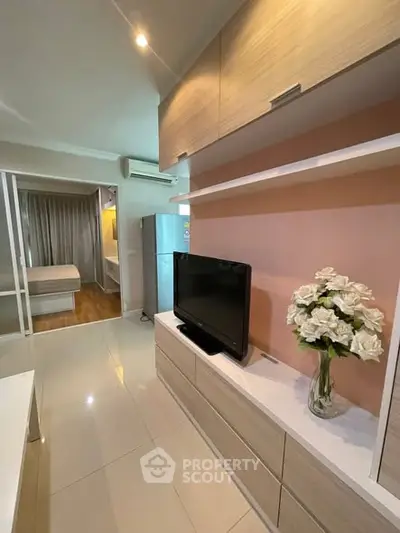 Modern living room with TV, sleek cabinetry, and elegant decor in a stylish apartment.