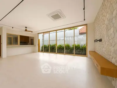 Spacious modern living room with large windows and stone accent wall