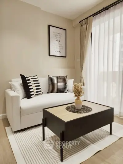 Stylish modern living room with cozy white sofa, chic decor, and natural light from large window.
