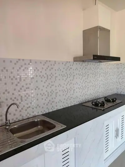 Modern kitchen with sleek gas stove and stylish backsplash in a contemporary home.