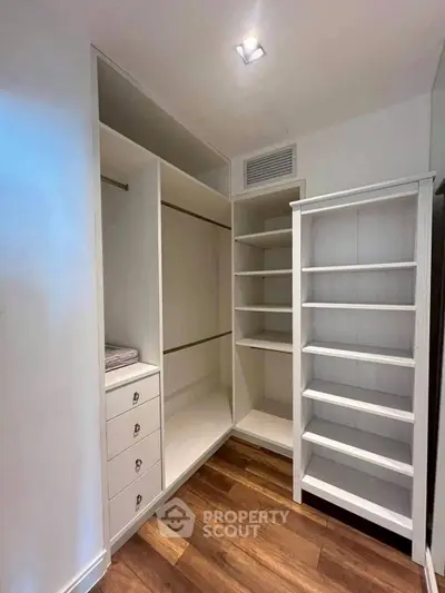 Spacious walk-in closet with wooden flooring and ample shelving