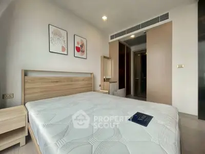 Modern bedroom with stylish decor and natural light, featuring a comfortable bed and elegant artwork.