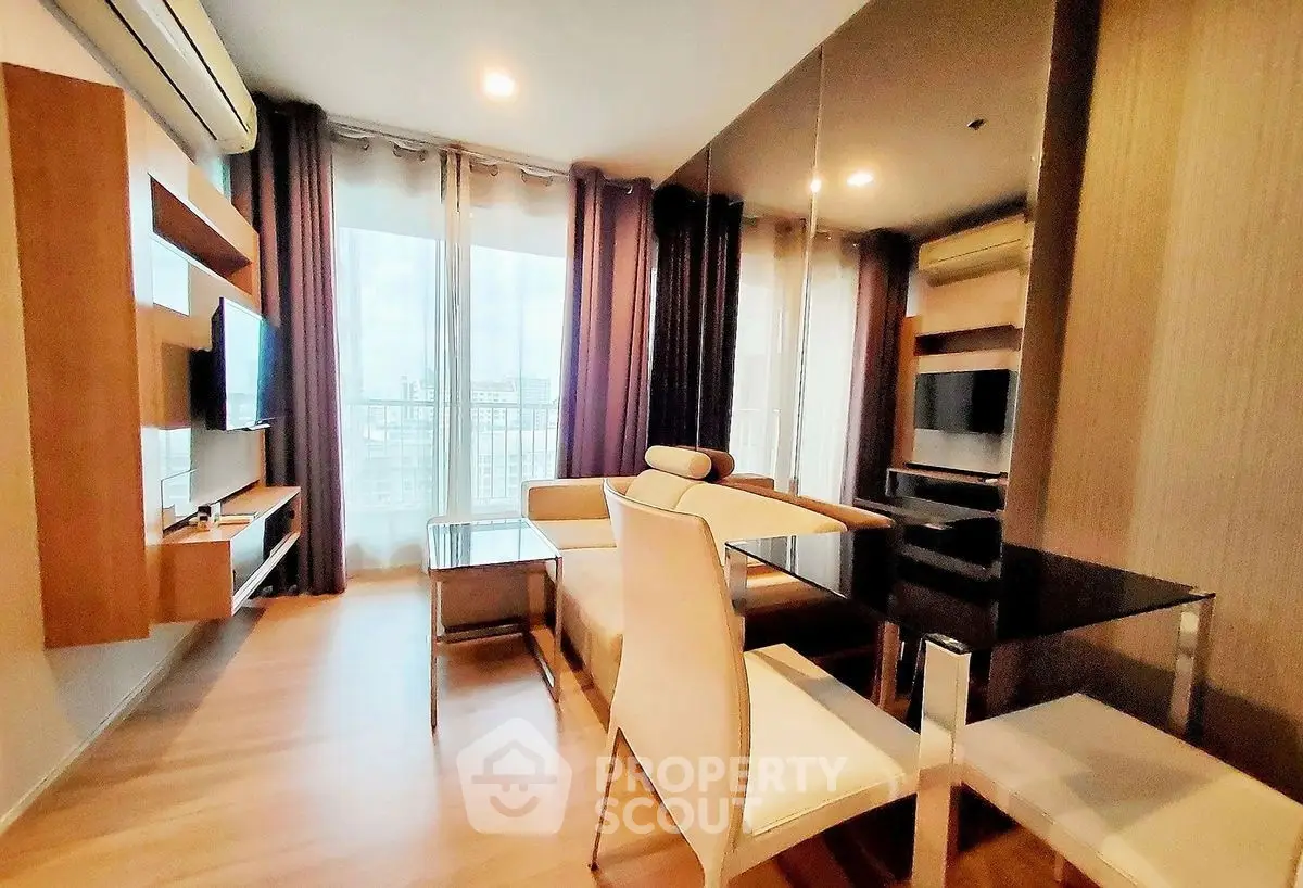 Modern living room with sleek furniture and large windows offering city views.