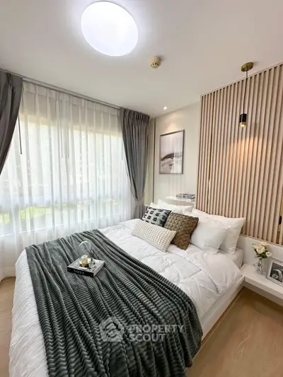 Modern bedroom with cozy decor and natural light, featuring elegant curtains and stylish wall design.