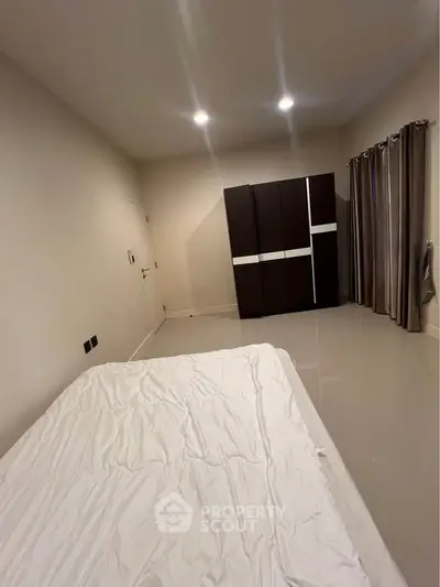 Spacious bedroom with modern wardrobe and elegant curtains, perfect for a cozy retreat.