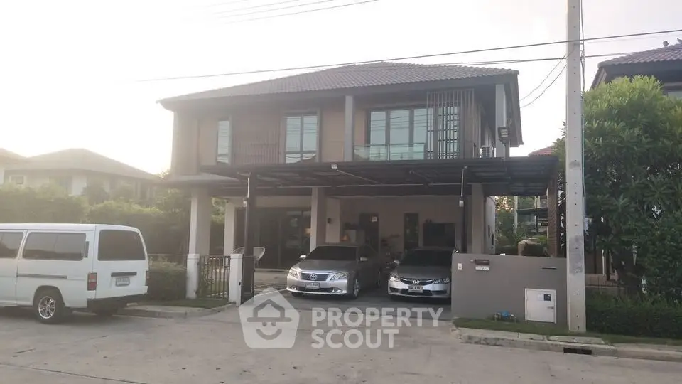 Modern two-story house with carport and driveway in suburban neighborhood.