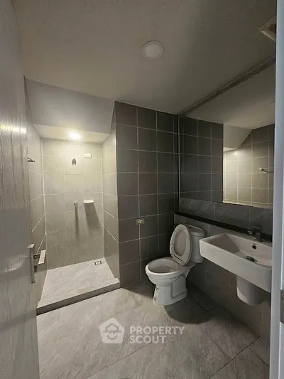 Modern bathroom with sleek gray tiles and open shower design