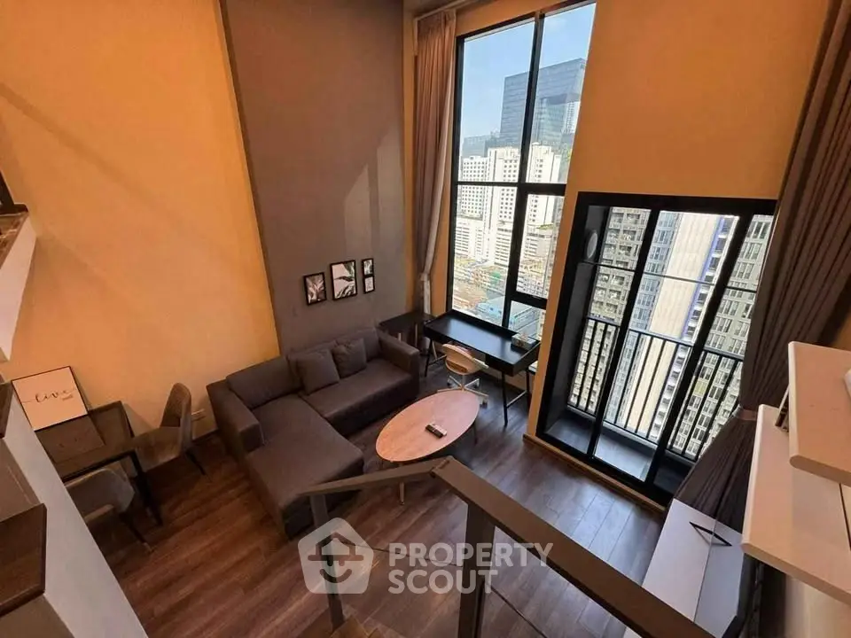 Modern loft-style living room with large windows and city view