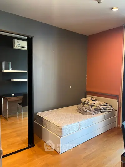 Cozy bedroom with wooden flooring and modern desk setup