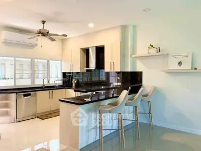 Modern kitchen with sleek countertops and bar seating in a bright open layout.