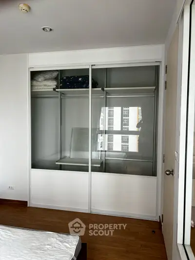 Spacious bedroom with built-in sliding door wardrobe and wooden flooring