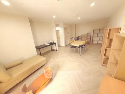 Spacious living room with modern furniture and ample natural light, perfect for relaxation and entertainment.