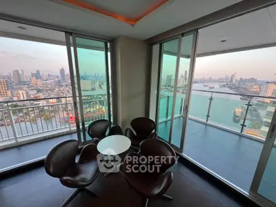 Stunning high-rise apartment with panoramic city and river views from a spacious balcony.
