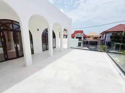 Stunning modern balcony with arched windows and expansive views in a luxurious residential area.