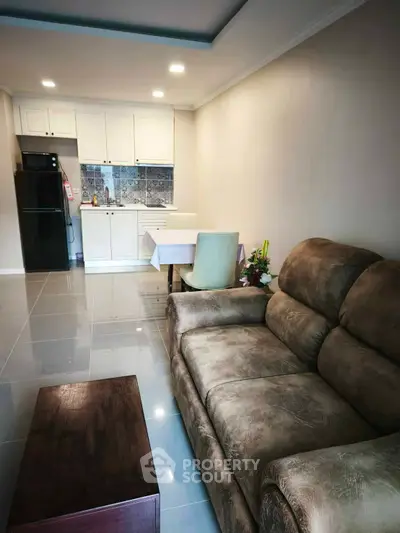 Cozy living room with plush sofa and modern kitchen in open layout apartment