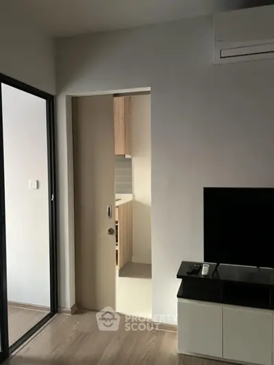 Modern apartment interior with sliding door and sleek TV setup